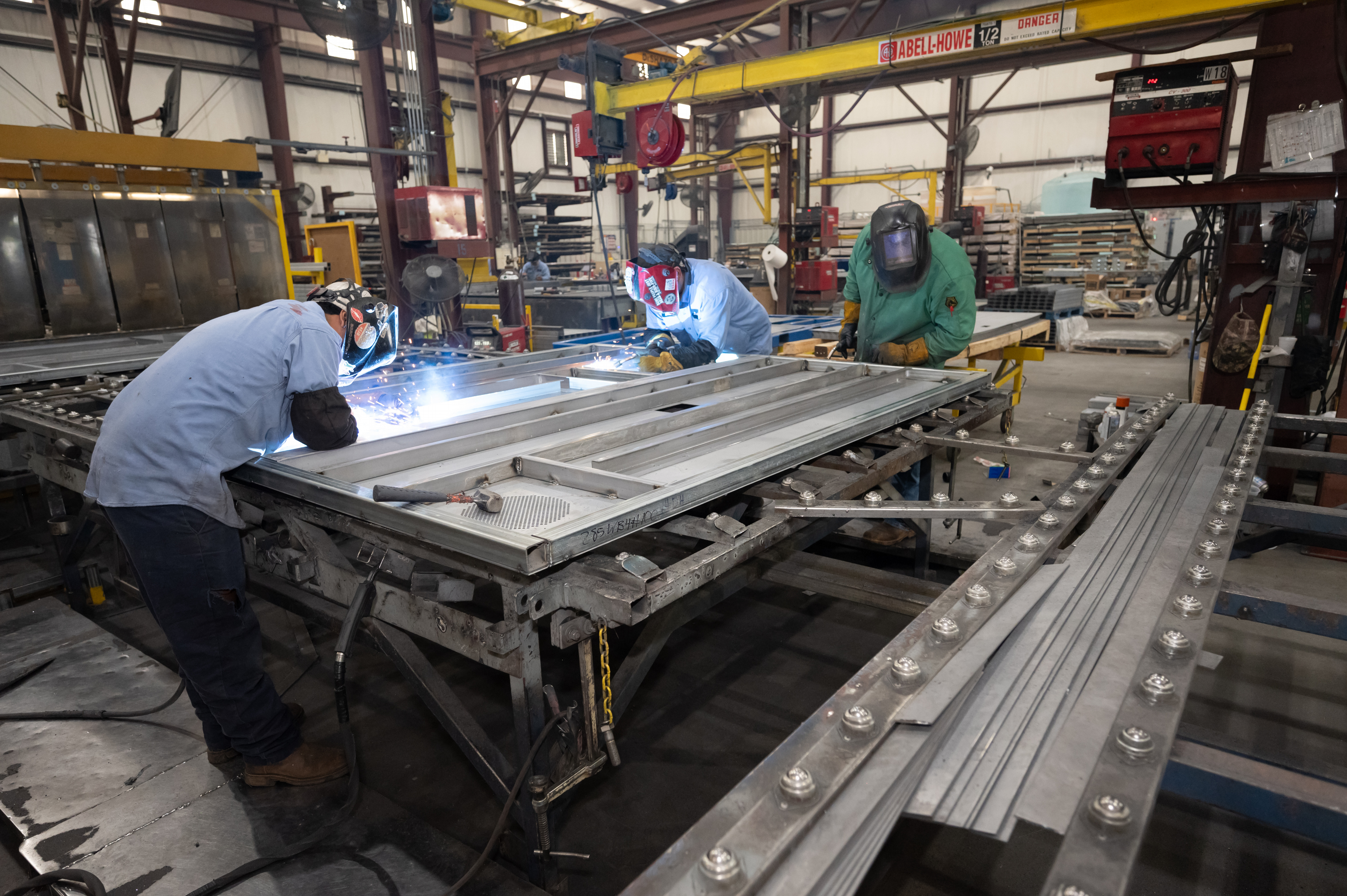 SteelCell team welding steel components in a controlled manufacturing facility